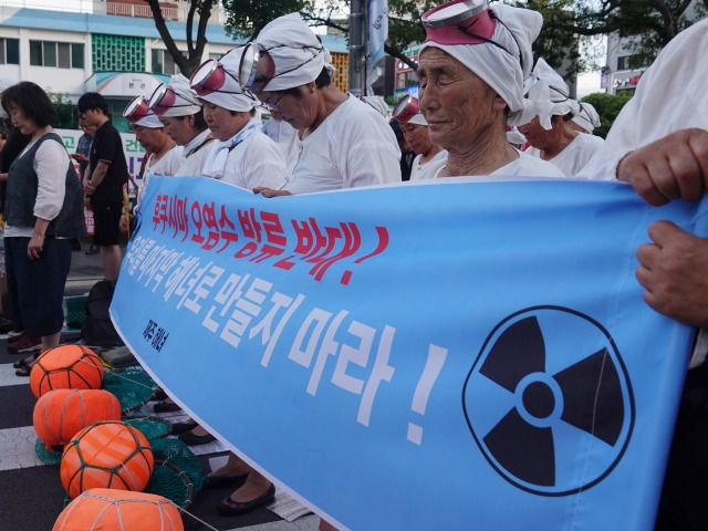 제주 해녀들이 12일 오후 제주시청 앞에서 열린 제2차 일본 후쿠시마 핵오염수 해양투기 및 CPTPP 저지 제주범도민 대회에서 국민의례를 하고 있다. 뉴시스