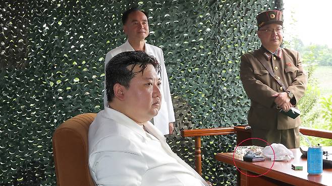 북한은 13일 전날 동해상으로 발사한 탄도미사일은 신형 고체연료 대륙간탄도미사일(ICBM) '화성-18형'이라고 공식 발표했다. 현지시찰한 김 위원장 앞 테이블에 신형 폴더블 스마트폰으로 추정되는 물체가 보인다. 연합뉴스