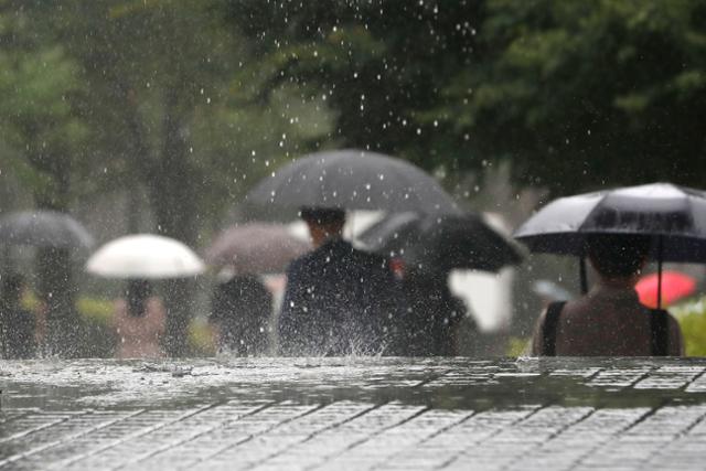 서울 서초구 서울중앙지방법원에서 시민들이 13일 쏟아지는 비를 피해 발걸음을 재촉하고 있다. 뉴시스