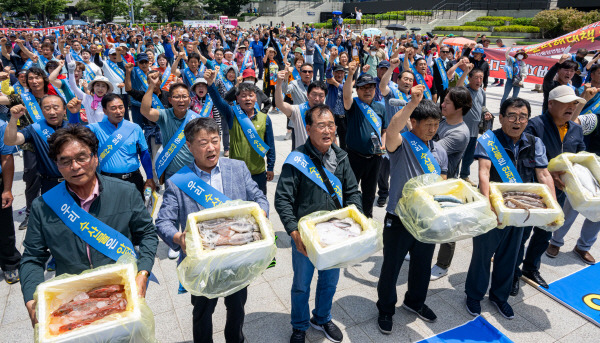 지난 7월 10일 부산역 앞 광장에서 열린 ‘우리 수산물 소비 촉진 어민 호소대회’ 중 어업인들이 수산물이 안전하다는 구호를 외치고 있다. 국제신문DB