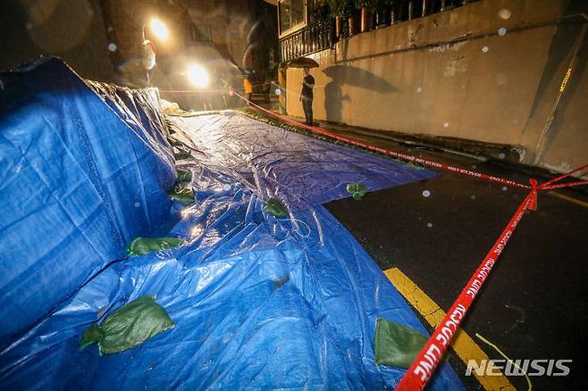 [서울=뉴시스] 황준선 기자 = 13일 오후 폭우로 축대가 무너진 서울 서대문구 홍제천로의 한 도로에 방수포가 덮혀있다. 이날 사고로 인명피해는 없었으나 인근 주민 20가구 46명이 대피했다. 2023.07.13. hwang@newsis.com