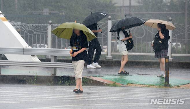 [전주=뉴시스] 김얼 기자 = 전북 대부분 지역에 호우경보가 발효된 14일 전북 전주시 완산구 효자동에서 학생들이 우산으로 비를 피하며 길을 지나고 있다. 2023.07.14. pmkeul@nwsis.com