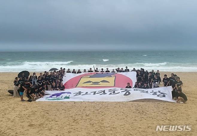 [부산=뉴시스] 이동민 기자 = 14일 오전 전국환경운동연합 활동가 100여명이 부산 해운대 해수욕장 백사장에 모여 방사능 마크가 그려진 현수막을 들고 구호를 외치고 있다. 2023.07.14. eastsky@newsis.com