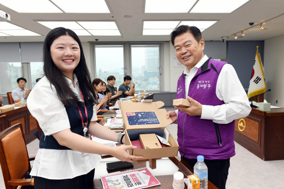 이필형(오른쪽) 동대문구청장이 동대문구 새내기 직원에게 웰컴키트를 전달하며 환하게 웃고 있다. 동대문구 제공