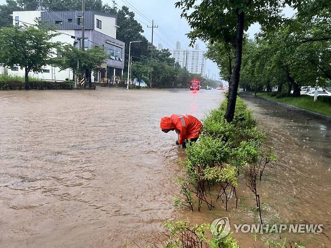 호우로 침수된 도로 (군산=연합뉴스) 전북 14개 시·군 전역에 호우 특보가 내려진 14일 오전 군산시 사정동의 한 도로가 침수돼 소방대원들이 배수 작업 중이다. 2023.7.14 [전북소방본부 제공. 재판매 및 DB 금지] warm@yna.co.kr