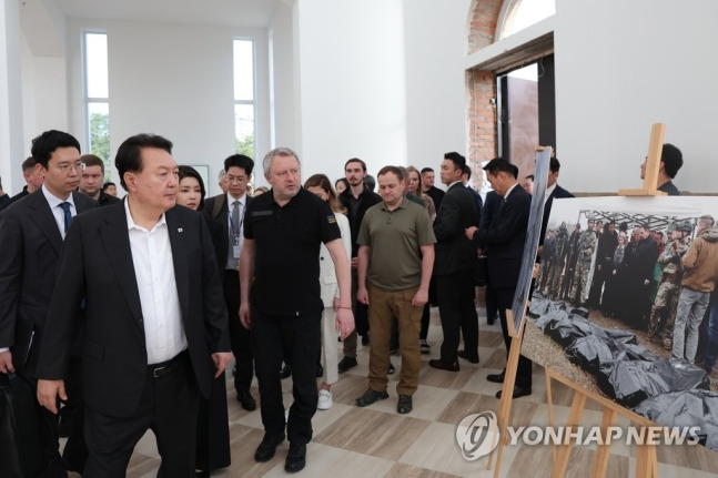 폴란드 수도 바르샤바에서 국빈급 공식 방문 일정을 마치고 우크라이나를 전격 방문한 윤석열 대통령이 15일(현지시간) 키이우 인근의 부차시 학살현장 관련 사진을 관람하고 있다. 윤 대통령은 이후 볼로디미르 젤렌스키 대통령과 정상회담을 열어 인도적 구호품을 포함한 지원 방안 등을 논의할 예정이다. [사진출처=연합뉴스]