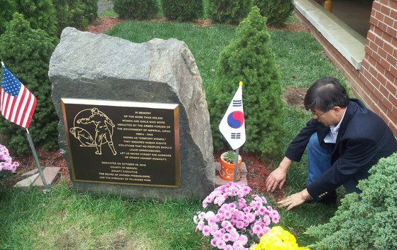 김동석 대표가 2012년 '말뚝 테러'가 발생한 뉴저지주 팰리세이즈파크 공립도서관 앞 위안부 기림비에서 말뚝이 박혔던 지점을 가리키고 있다. 연합뉴스