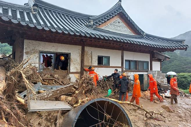 15일 경북 봉화군 춘양면 학산리에서 많은 비로 토사가 주택을 덮쳐 소방관들이 현장 수습에 나서고 있다. 사진=연합뉴스