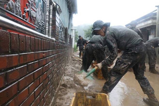 [서울=뉴시스] 육군 2작전사령부 50사단 장병들이 집중 호우로 인해 토사가 밀려든 경북 예천군 감천면 가옥과 도로에 토사를 걷어내고 있다. (사진=육군 제공) 2023.07.15. photo@newsis.com  *재판매 및 DB 금지