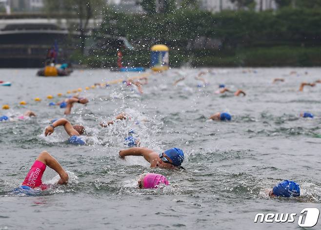 16일 오전 서울 송파구 롯데월드타워 일대에서 열린 '2023 롯데 아쿠아슬론 대회'에 출전한 참가자들이 석촌호수에서 수영을 하고 있다. 2023.7.16/뉴스1 ⓒ News1 신웅수 기자