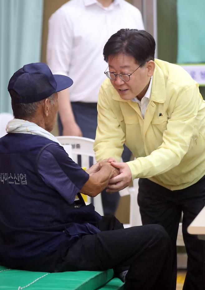 이재명 더불어민주당 대표(오른쪽)가 16일 오후 충북 괴산오성중학교에 마련된 괴산댐 월류 이재민 대피소에서 이재민을 위로하고 있다. 뉴스1