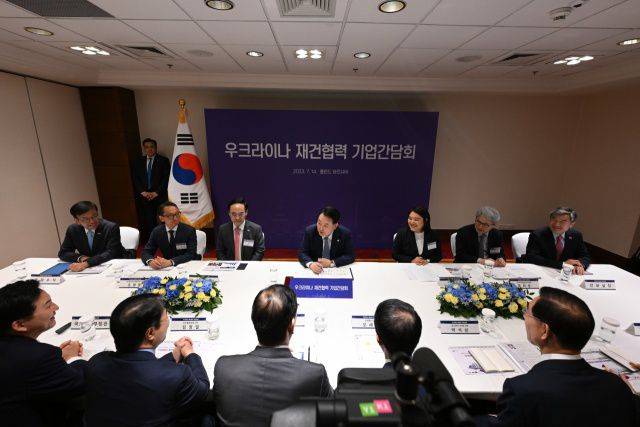 윤석열 대통령이 14일(현지시각) 폴란드 바르샤바 한 호텔에서 열린 우크라이나 재건 협력 기업 간담회에서 채선주 네이버 대외·ESG 정책 대표 등 참석자들과 대화하고 있다./연합뉴스