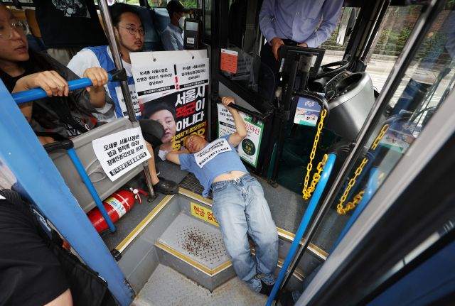 전국장애인차별철폐연대 활동가가 17일 오후 혜화동로터리 버스정류장에서 '서울시의 전장연 탄압 중단'을 촉구하며 버스 탑승 시위를 벌이고 있다. 연합뉴스