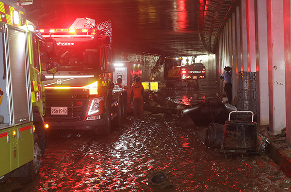 Drainage work is under way in a flooded underpass in Osong, North Chungcheong Province on July 17. [Photo by Yonhap]