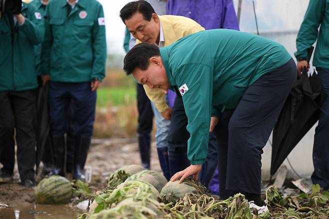 수해 입은 수박 농가 방문한 윤 대통령 윤석열 대통령이 18일 충남 논산시의 한 수박 재배 농가를 찾아 수해를 입은 비닐하우스를 둘러보고 있다. 대통령실 제공