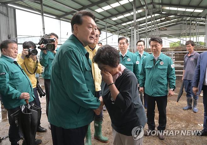 집중호우 피해 주민 위로하는 윤석열 대통령 (공주=연합뉴스) 진성철 기자 = 집중호우 피해 현장 방문에 나선 윤석열 대통령이 18일 충남 공주시 탄천면 한우 축산농가를 찾아 피해 주민을 위로하고 있다. 2023.7.18 zjin@yna.co.kr