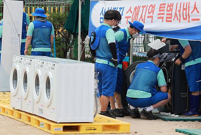 지난해 8월 15일 서울 관악구 남부초등학교 운동장에서 가전제품 기업 관계자들이 침수 피해를 입은 제품을 수리하고 있다. 행정안전부는 지난해 중부지방에 내린 집중호우로 침수 피해를 입은 취약지역에 가전제품 무상수리를 위한 ‘가전 3사 합동무상수리팀’을 운영했다. (사진=저작권자(c) 연합뉴스, 무단 전재-재배포 금지)