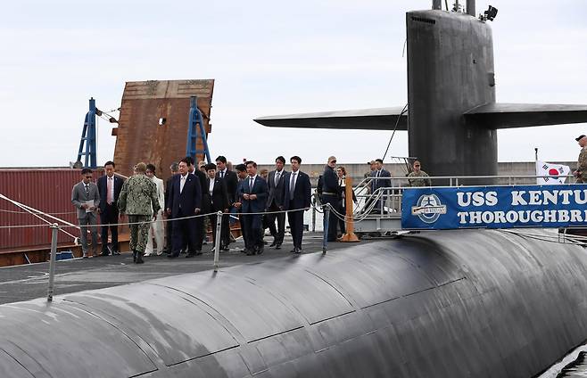 President Yoon Suk Yeol and first lady Kim Keon Hee board the US Navy's Ohio-class ballistic-missile submarine, the USS Kentucky, a day after the ship arrived at a Korean naval base near Busan, marking the first visit of a US nuclear-capable submarine in more than four decades, Tuesday. (Joint Press Corps)