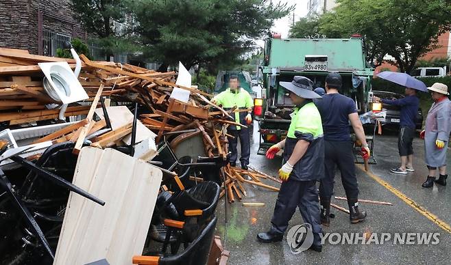 치워도 끝이 없는 쓰레기 (공주=연합뉴스) 이주형 기자 = 18일 오후 충남 공주에 굵은 장대비가 내리는 가운데, 공주시청 직원들이 침수 피해로 못 쓰게 된 가재도구를 수거하고 있다. 2023.7.18 coolee@yna.co.kr