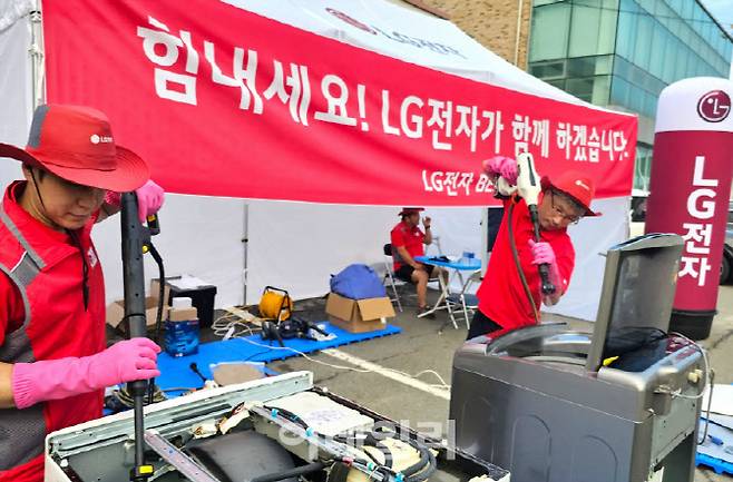 LG전자 서비스 매니저들이 지난 16일 충북 청주시 흥덕구 오송읍 행복복지센터에 수해 서비스 거점을 마련해 복구 활동을 하고 있다. 사진=LG