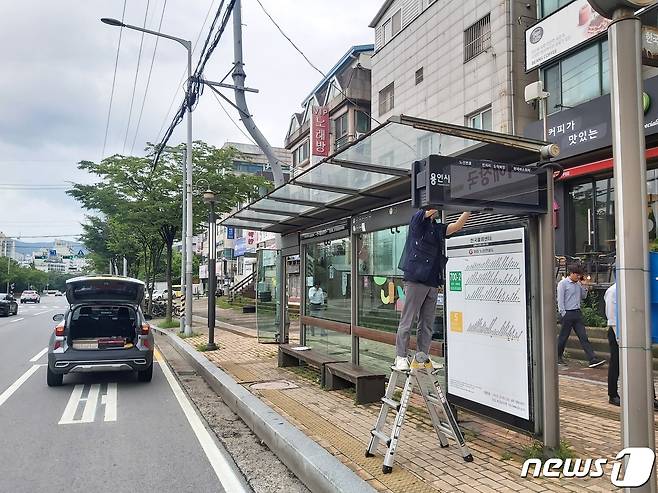 용인시 관계자가 버스정류소에 안내 전광판을 설치하고 있다.(용인시 제공)