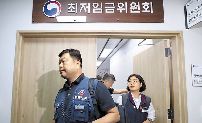 회의장 박차고 나오는 노동자 위원들 - 19일 새벽 정부세종청사 최저임금위원회 회의실에서 노동자 위원들이 나오고 있다. 최저임금위 노동자 위원들은 이날 최저임금 표결에 참여했지만, 항의 표시로 표결 직후 8명 전원이 집단 퇴장했다. /뉴시스