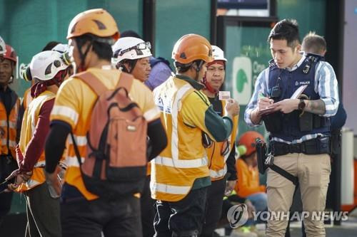 (오클랜드=AP 연합뉴스) 20일(현지시간) 오전 뉴질랜드 오클랜드의 한 건설 현장에서 발생한 총격 사건과 관련, 현지 경찰이 공사장 인부들을 상대로 목격자 진술을 듣고 있다. 2023.07.20