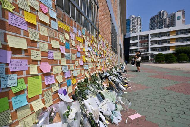 21일 서울 서초구 서이초등학교 체육관 벽이 스스로 목숨을 끊은 초등학교 교사를 추모하는 메시지로 가득 찬 가운데 시민들이 고인을 추모하고 있다. 최주연 기자