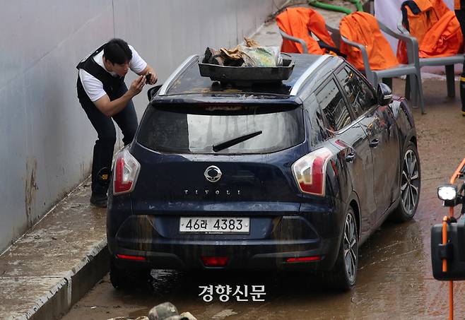 폭우로 인해 물에 잠긴 충북 청주 오송 지하차도에서 밤사이 시신 4구가 추가로 발견되며 사망자가 13명으로 집계된 가운데 17일 경찰들이 사고현장에서 끌어낸 차량을 살펴보고 있다.  권도현 기자