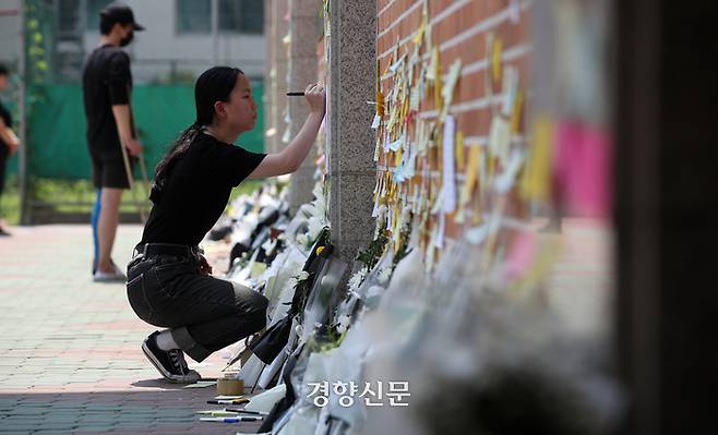 한 추모객이 추모 메시지를 작성하고 있다.