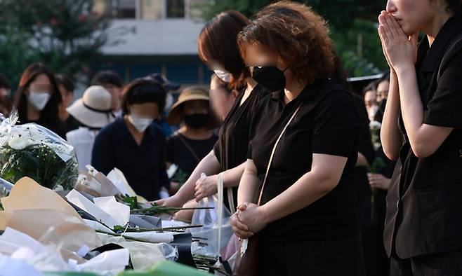 20일 서울 서초구 한 초등학교에서 추모객들이 임시 추모 공간 앞에서 헌화하고 추모 메시지를 남기고 있다. 연합뉴스