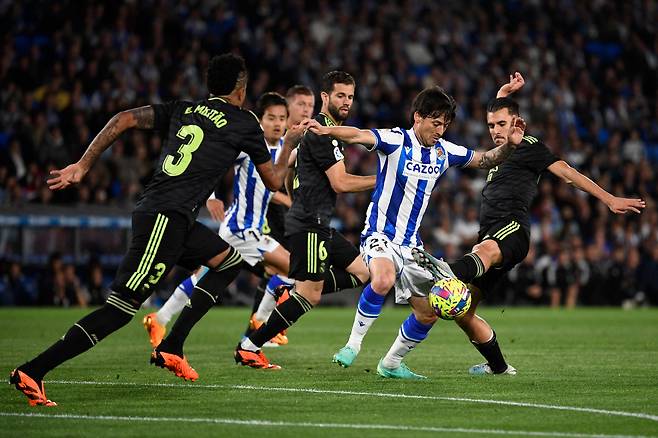 Real Madrid's Spanish midfielder Dani Ceballos (R) tackles Real Sociedad's Spanish midfielder David Silva (2R) during the Spanish league football match between Real Sociedad and Real Madrid CF at the Reale Arena stadium in San Sebastian on May 2, 2023. (Photo by ANDER GILLENEA / AFP)