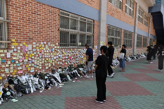 지난 21일 서울 서초구의 한 초등학교 건물 입구에 극단적 선택으로 세상을 떠난 이 학교 1학년 교사를 추모하는 스티커와 조화가 놓여있다. 윤운식 선임기자 yws@hani.co.kr