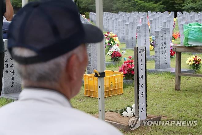 해병대 선배가 바라보는 후배의 마지막 모습 (대전=연합뉴스) 강수환 기자 = 22일 오후 국립대전현충원에서 거행된 고(故) 채수근 상병의 안장식이 끝나고 해병대 63기 박종옥 씨가 후배의 묘소를 바라보고 있다. 채수근 상병은 지난 19일 경북 예천 내성천에서 실종자를 수색하던 중 급류에 휩쓸려 숨졌다. 2023.7.22 swan@yna.co.kr