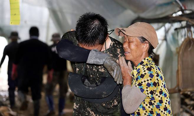 육군 제35보병사단의 수해 복구에 참가한 장병이 23일 특별재난지역으로 선포된 익산시 망성면 일대에서 이뤄진 작전 도중 땀을 닦자 할머니가 장병을 다독이고 있다. 익산=연합뉴스