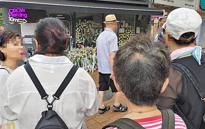 지난 21일 서울 지하철 신림역 인근 상가 골목에서 30대 남성이 지나가던 행인을 상대로 흉기를 휘둘러 1명이 숨지고 3명이 중상을 입는 사건이 발생한 가운데 지난 24일 범행 현장에 마련된&nbsp;추모공간을 주민들이 바라보고 있다.