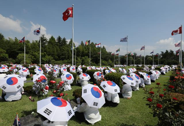 지난 달 부산 남구 유엔기념공원에서 열린 제73주년 6·25전쟁 참전 유엔군 전몰용사 추모제에서 태극기 우산을 쓴 참석자들이 유엔군 전몰용사를 추모하고 있다. 뉴스1