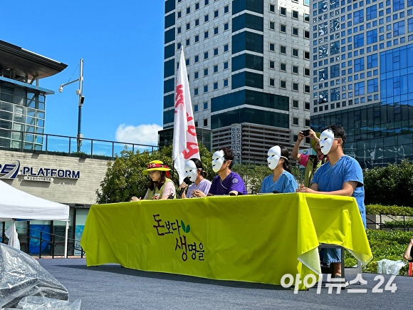 25일 부산 동구 부산역 광장에서 열린 ‘불법 의료 증언대회’에서 현직 간호사와 간호조무사 등 4명이 하얀색 가면을 쓰고 병원의 불법 의료 실태를 밝히고 있다. [사진=정예진 기자]