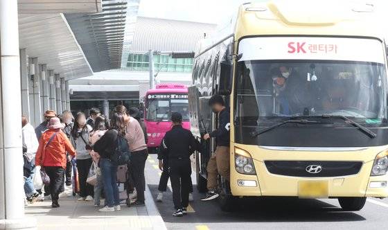 여행을 마친 관광객들이 렌터카 셔틀에서 내려 출발장으로 향하고 있다. 뉴스1