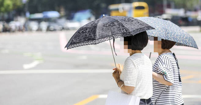 더운 날씨를 보인 지난 20일 서울 중구 세종대로에서 시민들이 양산으로 햇빛을 가린 채 이동하고 있다. /사진=뉴시스