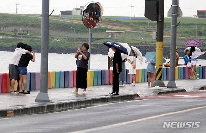 [제주=뉴시스] 오영재 기자 = 비가 내리는 25일 오전 제주시 도두동 무지개해안도로에서 관광객들이 즐거운 시간을 보내고 있다. 2023.07.25. oyj4343@newsis.com