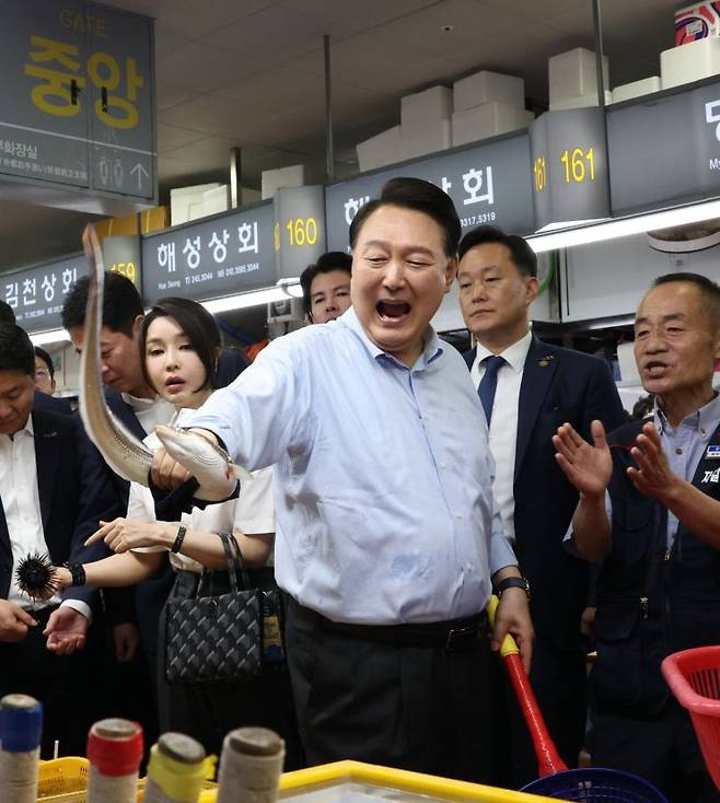 윤석열 대통령이 27일 부산 중구 자갈치시장에서 장어를 직접 손으로 잡고 있다. [이미지출처=연합뉴스]