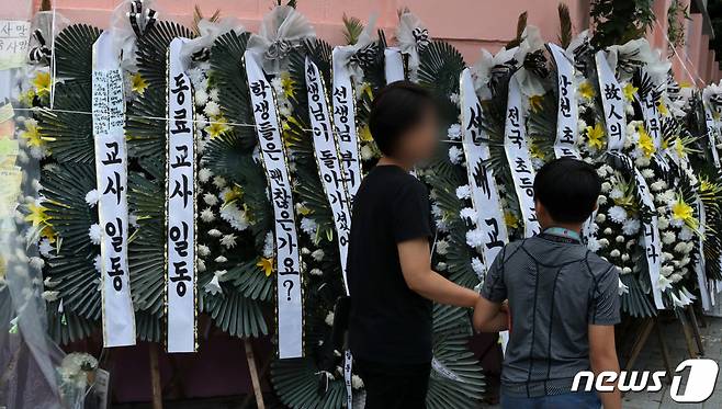 지난 25일 서울 서초구 서이초등학교를 찾은 한 모녀가 교내에서 극단 선택으로 숨진 교사를 위한 추모 메시지를 읽고 있다. /사진=뉴스1