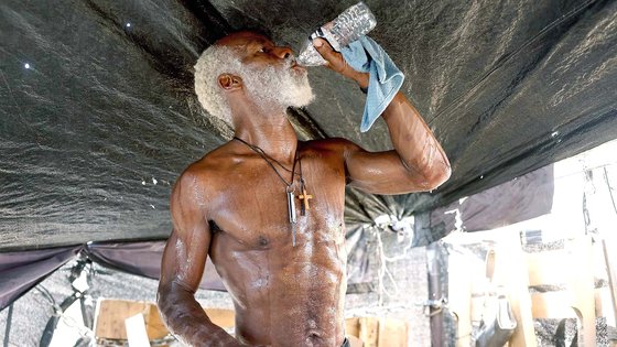 25일(현지시간) 미국 중서부 애리조나 피닉스시의 가장 큰 노숙자 시설에서 한 노숙자가 물을 마시고 있다. 그는 AFP에 ″직사광선이 너무 강해 정신착란을 일으킬 것 같다″고 했다. AFP=연합뉴스