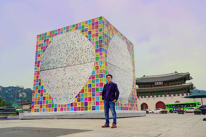 Kang Ik-joong poses with his installation "Gwanghwamun Arirang” shown in 2020 (Gallery Hyundai)