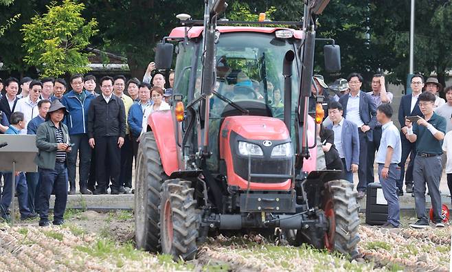 정황근 농림축산식품부 장관이 지난 6월 15일 경남 함양군 함양읍 용평리 양파 기계 수확 현장을 방문해 진병영 함양군수와 농민들의 양파 기계화 수확 작업을 지켜보고 있다. (연합뉴스)