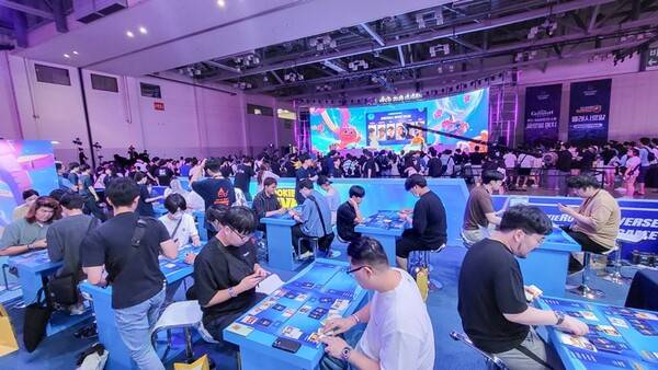 지난 30일 부산 벡스코 'WCG 2023' 스테이지에서 이창헌 데브시스터즈 PD가 '쿠키런: 브레이버스' 키노트를 진행되는 동안 쿠키런 부스 내 TCG 플레이존에서는 관람객들이 게임을 플레이가 하고 있다. (사진=안신혜 기자)