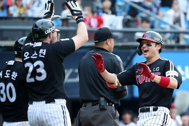 프로야구 LG의 박해민(오른쪽)이 30일 서울 잠실구장에서 열린 두산과의 ‘잠실 더비’에서 4-0으로 앞선 3회초 2사 만루 상황에 좌전 안타를 때려낸 뒤 이어 포수의 3루수 송구 실책에 홈인하며 동료들과 기뻐하고 있다. 뉴스1