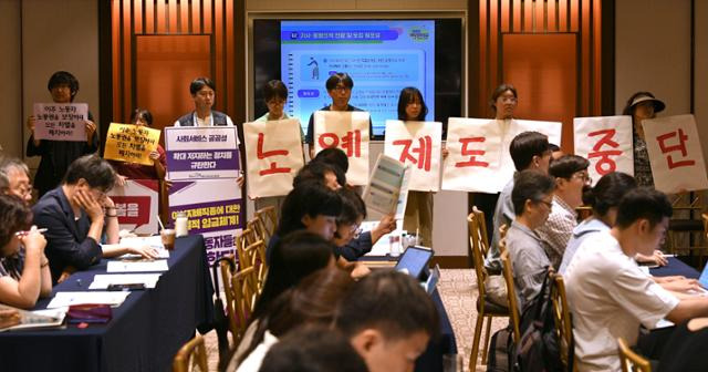 한국여성노동자회 등 시민사회단체 회원들이 31일 서울 중구 로얄호텔에서 고용노동부 주최로 열린 '외국인 가사근로자 도입 시범 사업' 공청회에서 피켓 시위를 하고 있다. 윤서영 인턴기자