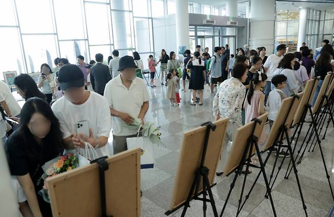 지난 28일 '50년 후의 바다상상하기 그림공모전' 시상식이  열린 부산 국립해양박물관 대강당 앞에 마련된 공모전 수상작 전시관에서 관람객들이 작품들을 둘러보고 있다/사진= 김휘선 기자